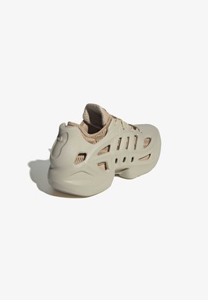 Baskets beiges avec une coque extérieure sculptée et ventilée et une doublure intérieure rembourrée, inclinées pour montrer le profil arrière et latéral.