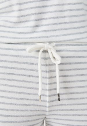 Conjunto de loungewear a rayas blancas y grises con cintura ajustable, con lazos blancos y puntas metálicas. Textura suave, diseño casual.