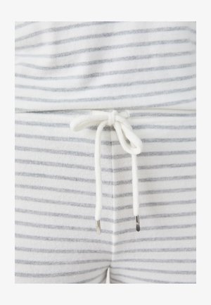 Loungewear bianco e grigio a righe con vita regolabile e lacci bianchi con punte metalliche. Texture morbida, design informale.
