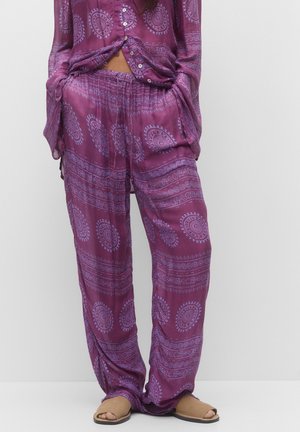 Set da lounge a motivo viola realizzato in tessuto morbido. La parte superiore presenta bottoni e maniche lunghe; i pantaloni hanno una vestibilità comoda con vita elastica.