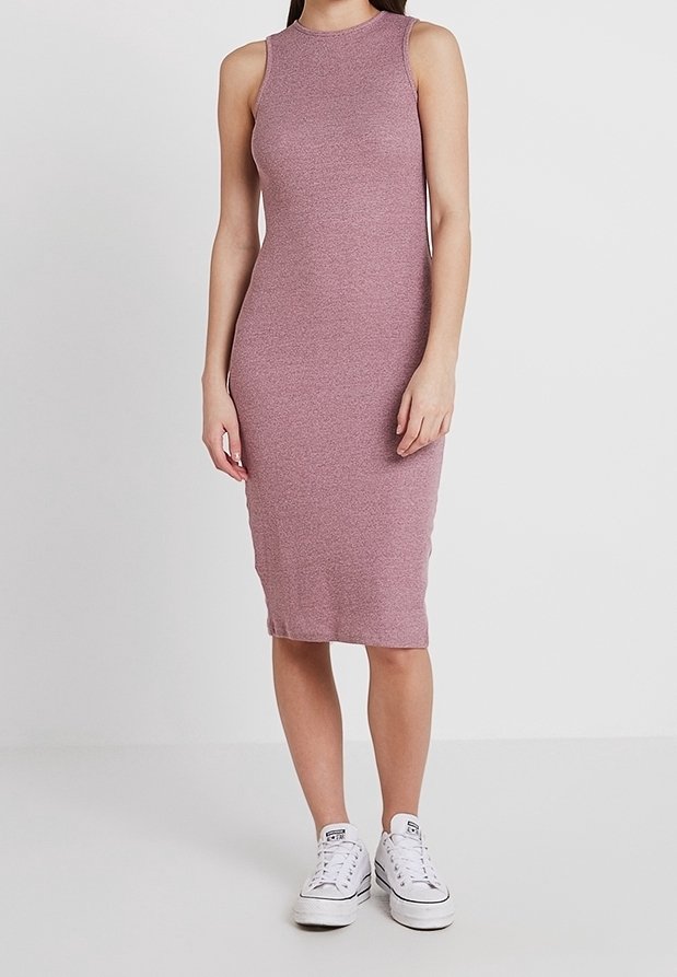 Robe midi sans manches rose côtelée en tissu extensible ; silhouette ajustée ; associée à des baskets blanches pour un contraste.