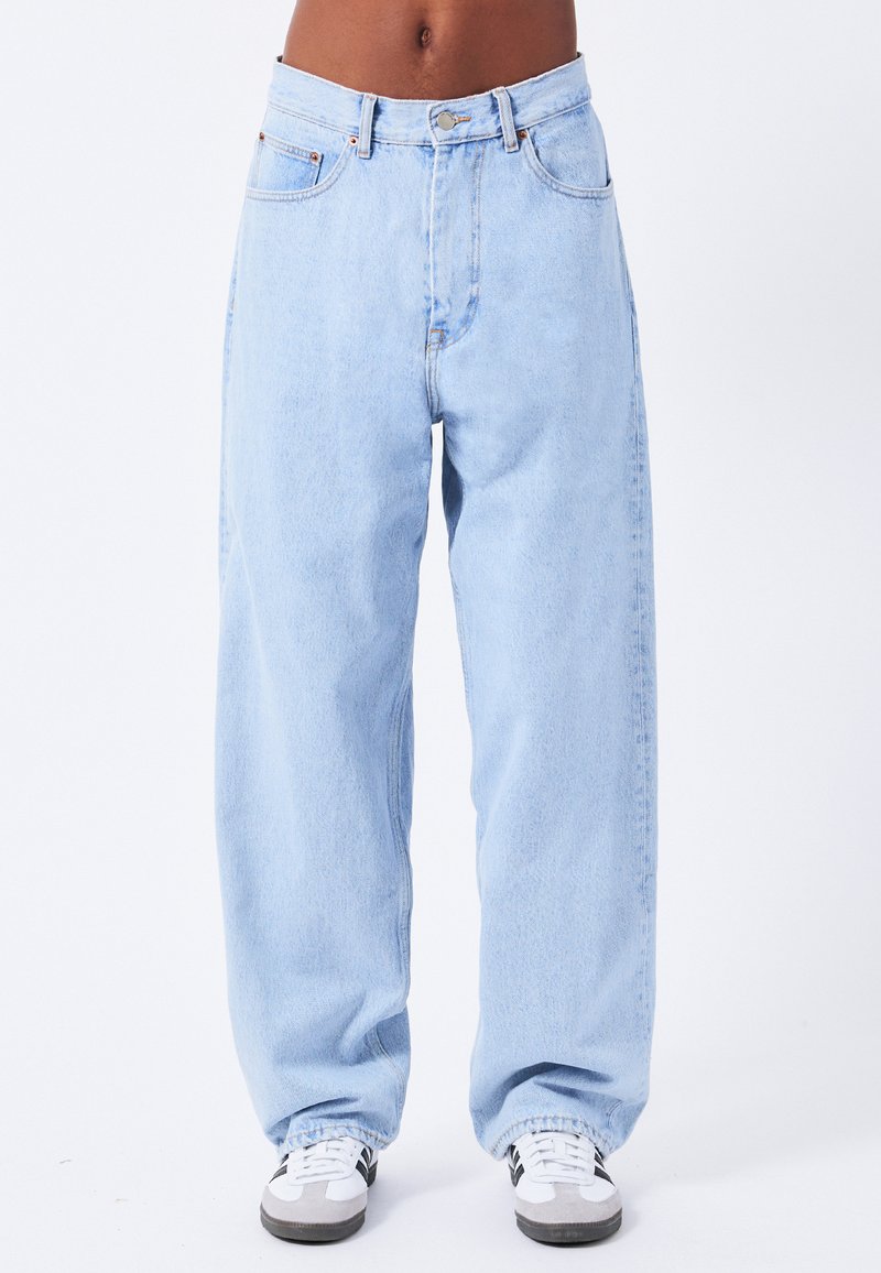 Lys blå denim jeans med løs pasform, høj talje og indsnørede stropher. Har frontlommer og en lynlås med knaplukning.
