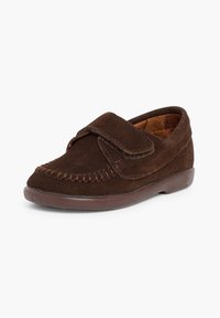 Scarpa in suede marrone con punta arrotondata, dettagli cuciti e cinturino in Velcro regolabile. Suola piatta in gomma per supporto.