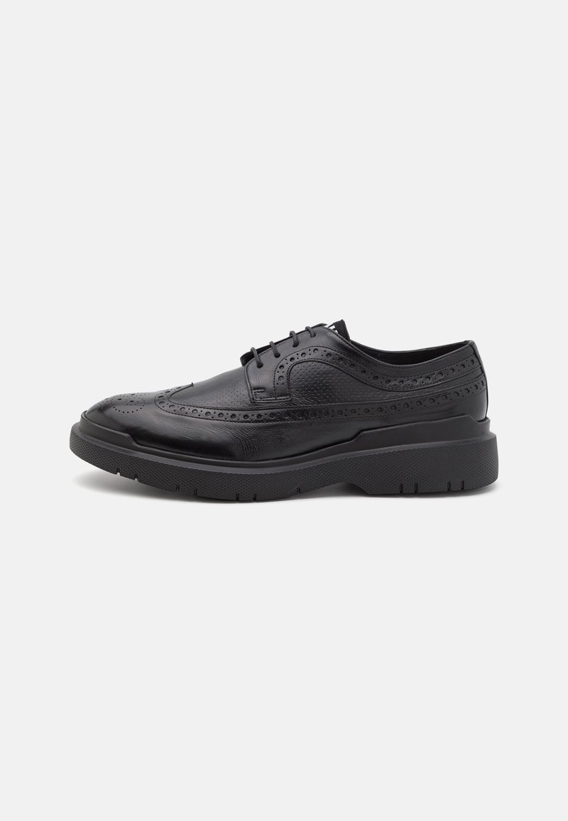 Scarpe da uomo in pelle nera con dettagli brogue, punta arrotondata e suola testurizzata. Presentano un design con lacci e un'altezza del tacco moderata.