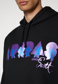 Sweatshirt preto com estampagem gráfica multicolorida em tons de azul e púrpura, apresentando figuras estilizadas e o texto "Jeremy Scott". Corda ajustável.