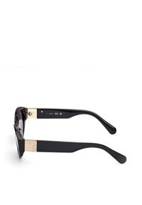 Černé sluneční brýle s robustním rámem, které mají zlaté kovové detaily na stranicích a tmavé čočky. Texturované akcenty na rameni.