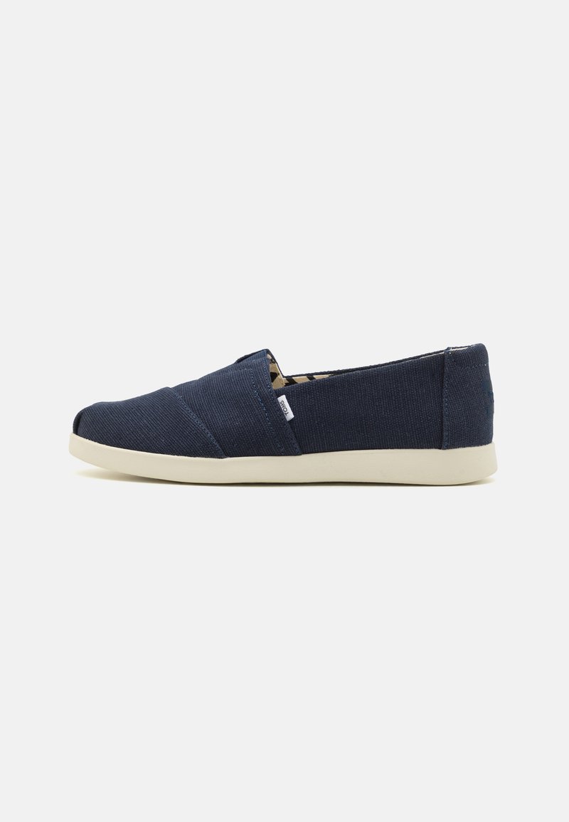 Marinede blå slip-on sko med et teksturert stoffoverdel, hvit gummisåle og designpryd med kryssøm. Minimalistisk stil med elastiske sider.