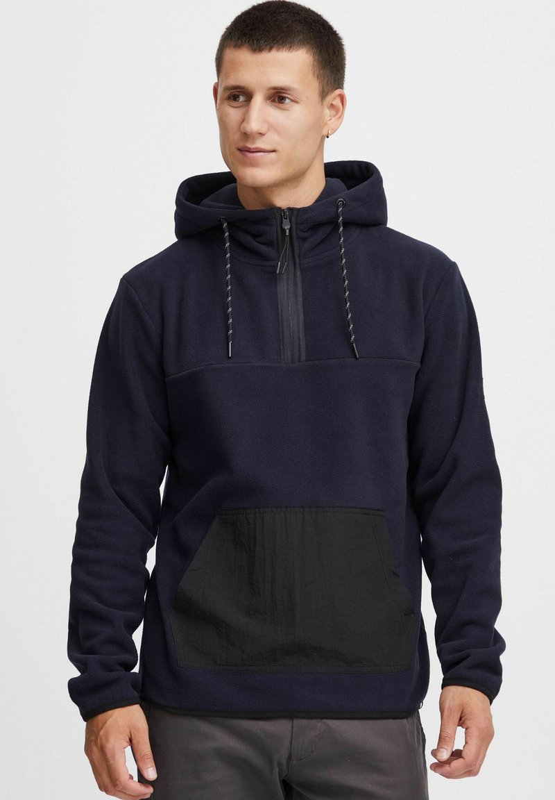 Hooded pullover van marineblauw fleece met een halve rits en een zwarte ripstop zak. Voorzien van een verstelbare trekkoord en textuurdetails in de stof.