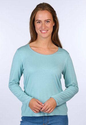 Heller blauer Langarmshirt mit rundem Ausschnitt, gerippten Saumdetails und einer glatten, weichen Textur. Kombiniert mit Jeans.