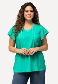 Top corto azzurro con maniche a palloncino e scollatura a V, caratterizzato da decorazioni in cucitura verticale e una vestibilità ampia. Il tessuto appare morbido e leggero.