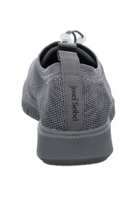 Gray athletic shoe with a textured mesh upper, rounded toe, pull tab, and contrasting rubber sole. Features adjustable lacing system.