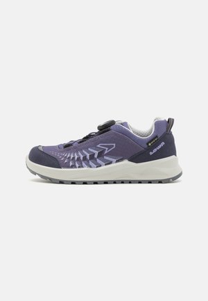 Purple athletic shoe featuring a textured design, mesh upper, reinforced toe cap, and a gray outsole with treads for traction.