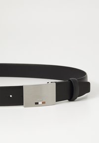 Black belt made of leather, featuring a rectangular silver metal buckle with the brand name "BOSS" and three color accents. Smooth texture.