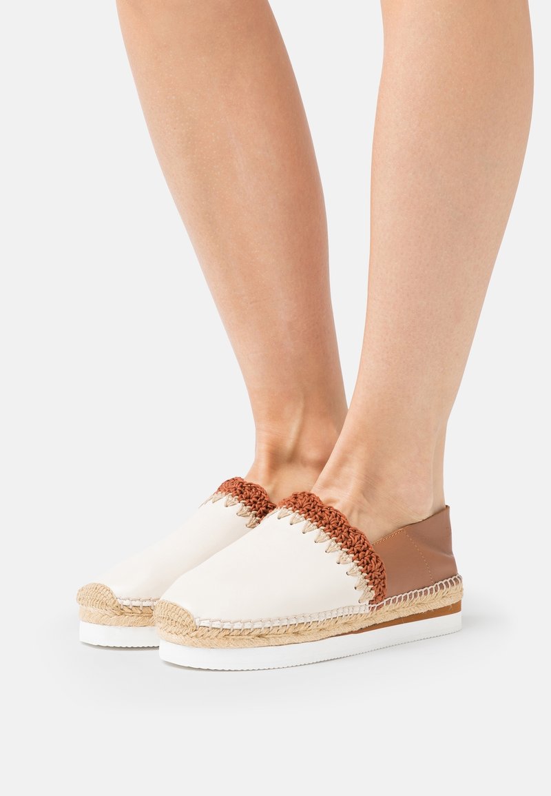 Espadrillos i tan og creme med hæklede detaljer, juteelementer og en hvid gummisål. Åben design med en glat læderbag.
