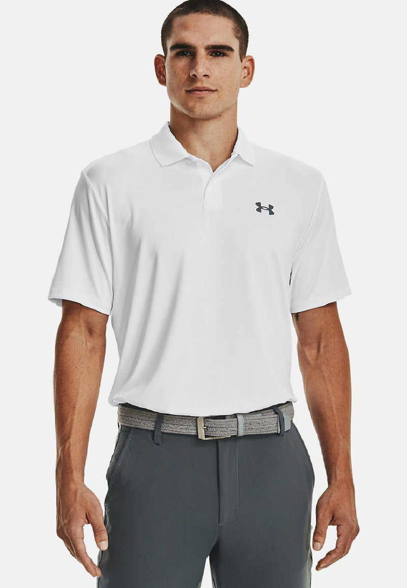 Hvid poloshirt med krave, forsynet med et lille gråt Under Armour-logo. Båret med grå bukser og et gråstribet bælte. Glat stofoverflade.