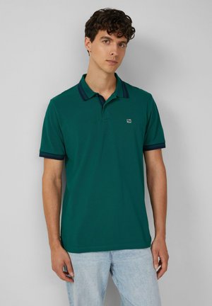 Türkise Polo-Shirt mit entspannter Passform, kontrastierendem dunkelblauen Kragen und Ärmelbündchen, kurzen Ärmeln und kleinem Logo auf der Brust.