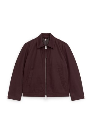 Giacca marrone scuro con zip, collo, maniche lunghe e due tasche frontali a filetto, distesa su uno sfondo bianco.