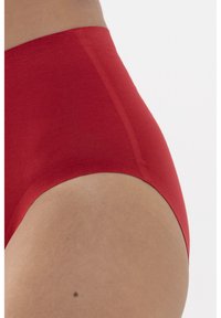 Červené vysoce pasové spodní prádlo vyrobené z hladké, elastické látky. Obsahuje bezešvý design a zakřivený střih podél otvoru pro nohy.