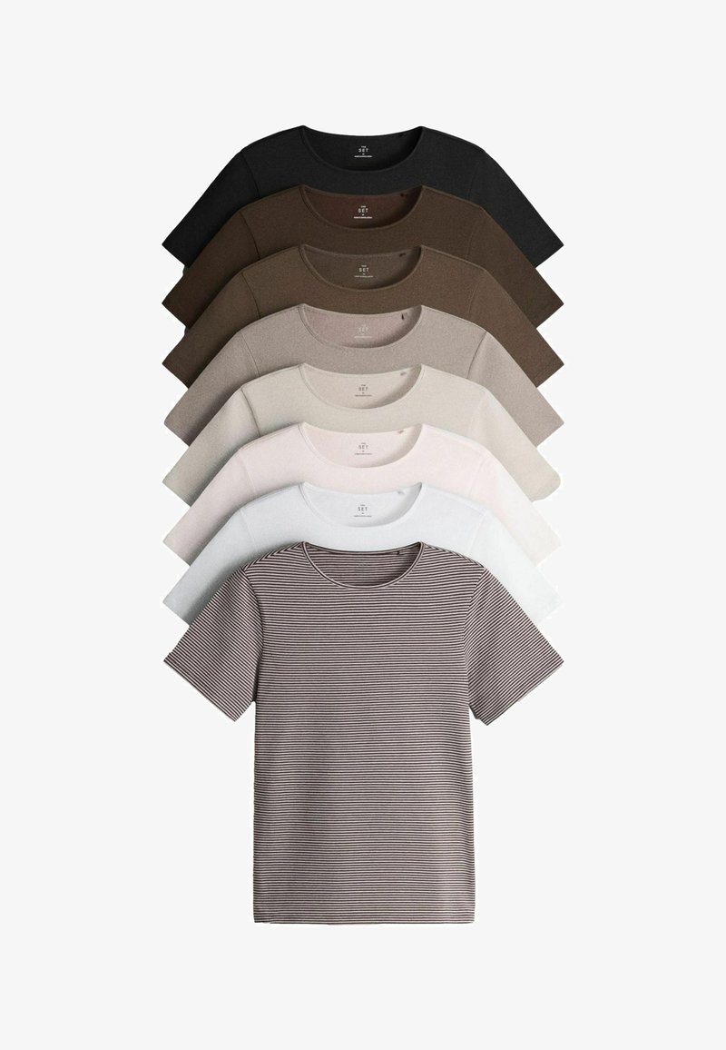 Sept t-shirts à manches courtes col rond en noir, nuances de marron, beige, blanc et motifs rayés, disposés en pile superposée.