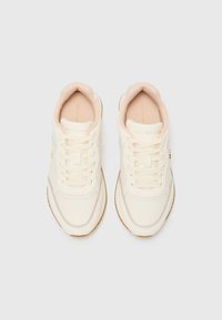 Hvite sneakers med lyserosa detaljer. Glatt materiale, rund tå, snøring og en teksturert gummisåle. Har logo på siden.