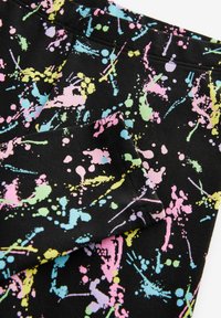 Schwarzer Stoff mit buntem Farbspritzmuster in Pink, Gelb und Blau. Hat eine glatte Textur und ein gefaltetes Kanten-Detail.