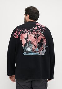 Black sweatshirt featuring a colorful graphic design of cherry blossoms, a koi fish, and a stylized circular pattern on the back.