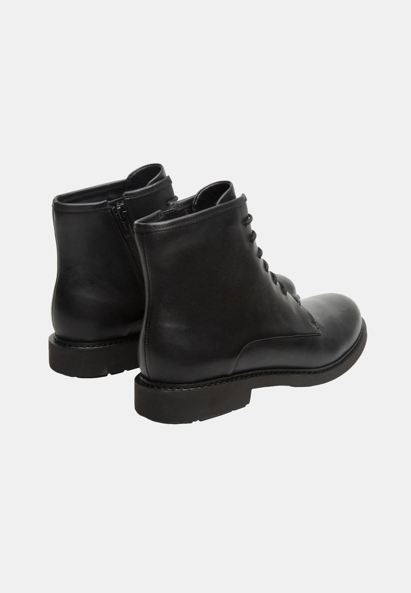 Botas de tobillo de cuero negro con punta redonda, cordones en la parte delantera y zipper lateral. Textura suave y costuras reforzadas a lo largo de la suela.