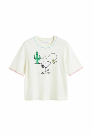 T-shirt blanc à manches courtes présentant un design de Snoopy et d'un cactus, avec des accents de bleu et de rose en forme de vagues autour de l'encolure et des manches.