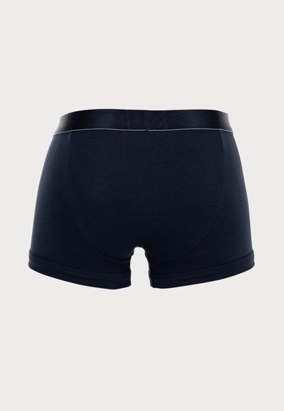 Navy blue boxer shorts made of soft fabric, featuring a black elastic waistband and seamless edges for a smooth finish.