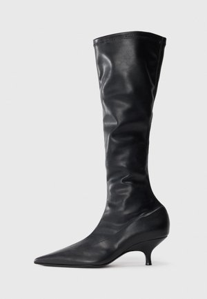 Bottes noires en cuir montant jusqu'au genou, avec un bout pointu et un talon fin et courbé. Texture douce et finition lisse avec des détails de couture minimaux.