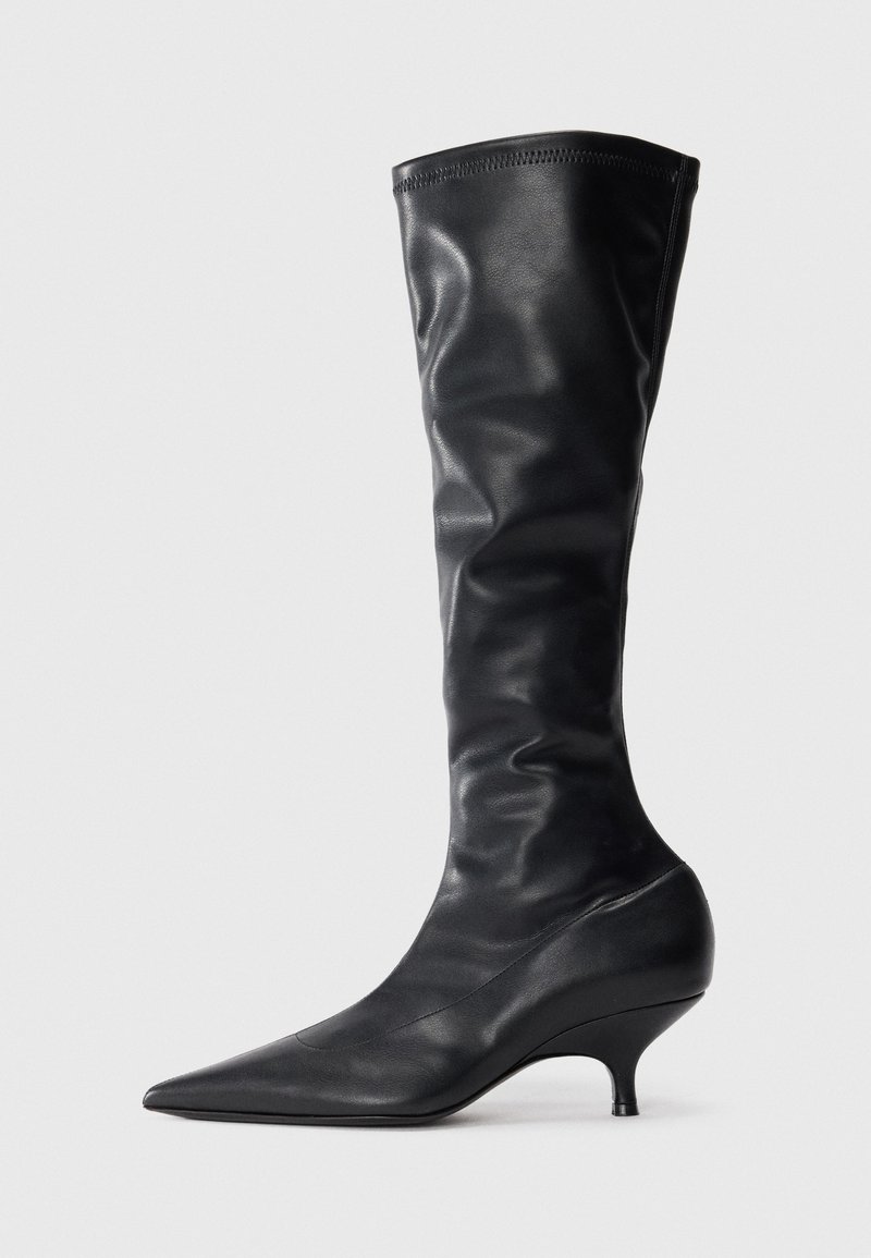 Black leather knee-high boots with a pointed toe and a slim, curved heel. Soft texture and a smooth finish with minimal stitching details.