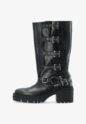 Sorte læder knæhøje støvler med fire sølv spænder, en tyk platformssål og nitter omkring anklen.