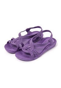 Par de sandalias moradas de punta abierta con correas trenzadas y soporte en el tobillo, diseñadas para uso casual, mostradas sobre fondo blanco.
