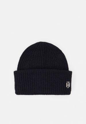 Bonnet en maille côtelée noire avec revers plié et petit logo "TH" brodé en blanc sur le côté inférieur droit du revers.
