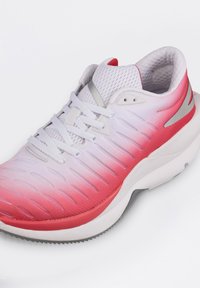 Roter und weißer Sportschuh mit einem strukturierten Mesh-Obermaterial, Farbverlauf, Schnürsenkeln und reflektierenden Silberakzenten an den Seiten.