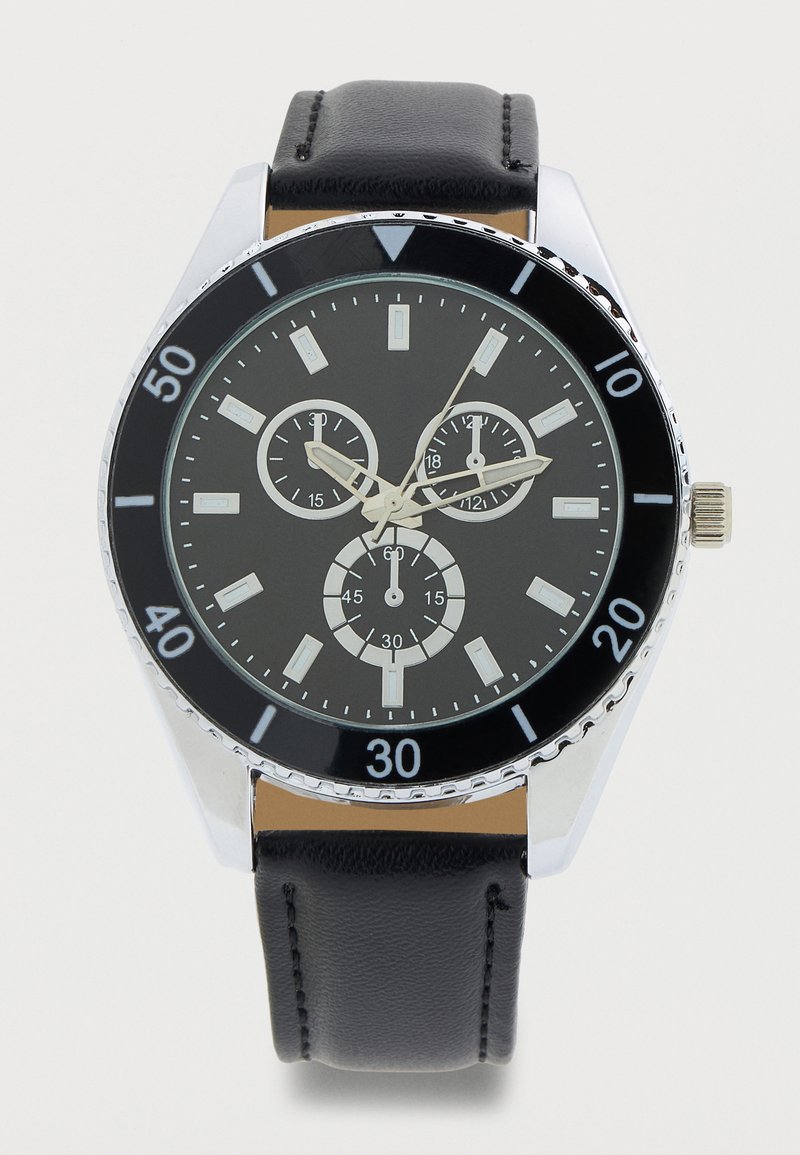 Svart armbåndsur med sølvfarget bezel, svart lærrem, tre underskiver og sølvfargede time-, minutt- og sekundvisere som viser klokken 2:52:06.