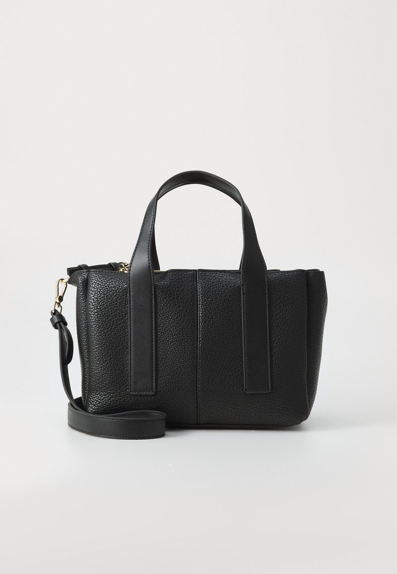 Sac à main en cuir noir texturé avec deux poignées courtes, une bandoulière amovible et une fermeture éclair sur le dessus sur un fond uni.