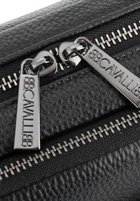 Black textured leather bag featuring silver zipper hardware and branded zipper pulls with "BB.CAVALLI" engraving. Zipper teeth are visible.