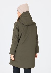 Olivgrön, huva-kappa i mjuk väv med avslappnad passform, långa ärmar och en medellång design. Har avtagbar huva och diskreta sömmar.