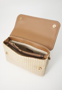 Woven beige handbag with a structured shape, gold accents, and a brown interior. Features a zip pocket and a snap closure.