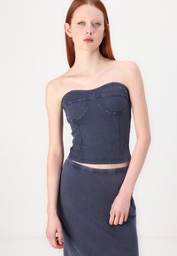 Top aderente senza spalline in tessuto a costine blu scuro con dettagli delle cuciture e un design del busto strutturato, abbinato a una gonna coordinata.