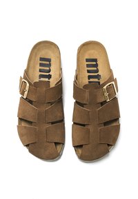 Sandales en suède marron avec un design de brides croisées, dotées d'une boucle métallique et d'une semelle intérieure texturée. Logo imprimé sur la semelle.