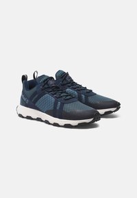 Zapatillas de malla en azul marino y aguamarina con suela de goma, paneles texturizados, puntera reforzada y una lengüeta en el talón para ponérselas fácilmente.