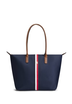 Sac cabas bleu marine avec poignées en cuir marron et une bande verticale rouge, blanche et bleue au centre avec un petit logo doré.
