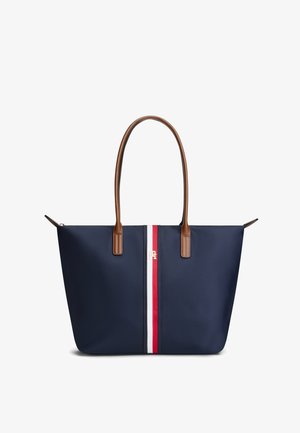 Sac cabas bleu marine avec poignées en cuir marron et une bande verticale rouge, blanche et bleue au centre avec un petit logo doré.