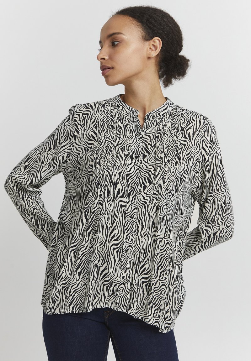 Zwart-wit zebraprint bloes met lange mouwen en een Mandarin kraag, voorzien van geplooide details en een relaxte pasvorm.