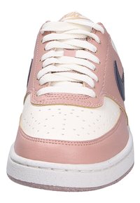 Baskets en cuir rose avec des accents blancs, boîte à orteils perforée et lacets blancs. Présentent un swoosh noir de Nike et une semelle blanche texturée.