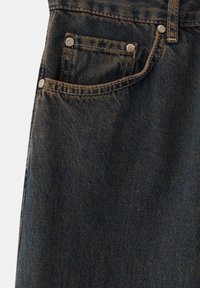 Jeans in denim blu scuro con cuciture visibili, tasca frontale con rivetti d'argento e una finitura strutturata che indica usura.