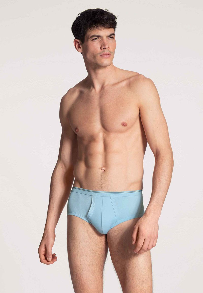 Lichtblauwe herenslips gemaakt van een zachte stof. Heeft een snug fit, een elastische tailleband en een minimalistisch ontwerp zonder patronen of accenten.