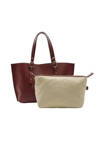 Bordowa skórzana torba tote z perforowanym wzorem i podwójnymi uchwytami, w połączeniu z beżową torbą płócienną z zamkiem błyskawicznym.
